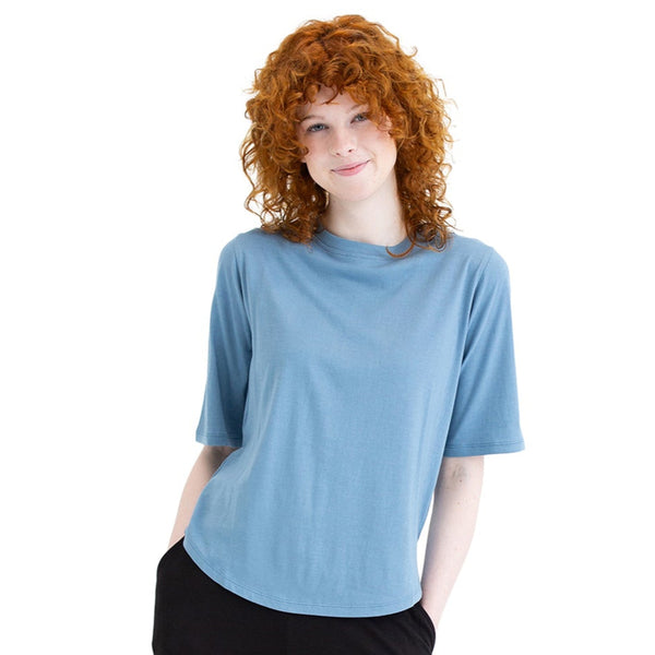 Person wearing a blue shirt and black pants on a white background