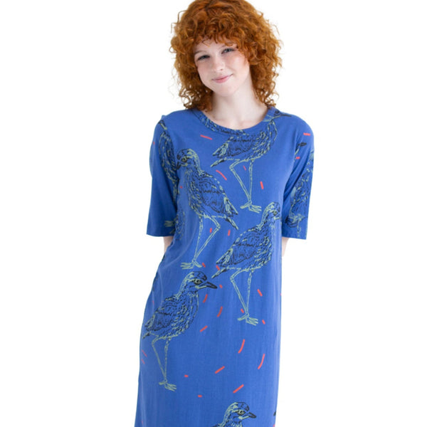 Woman wearing a blue dress with animal prints on a white background