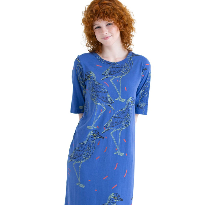 Woman wearing a blue dress with animal prints on a white background